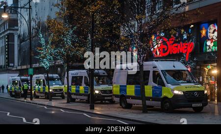 Des fourgonnettes de police à l'extérieur du magasin Disney sur Oxford Street pendant le confinement en cas de pandémie à Londres. Banque D'Images