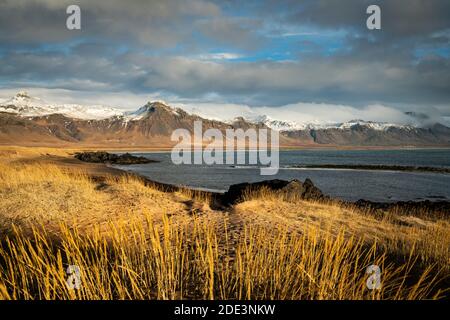 Vue panoramique des montagnes enneigées contre le ciel nuageux, Budir, péninsule de Snaefellsnes, Islande Banque D'Images