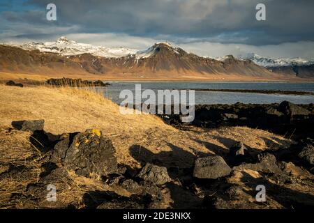 Vue panoramique des montagnes enneigées contre le ciel nuageux, Budir, péninsule de Snaefellsnes, Islande Banque D'Images