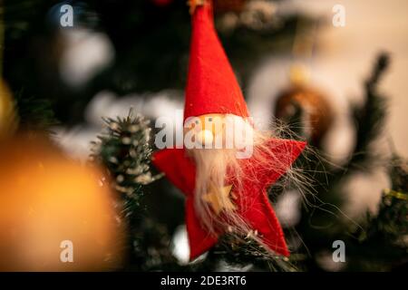 Thème de la nouvelle année. Gros plan. Le jouet de Noël du père noël en vestons rouges est suspendu sur les aiguilles vertes d'un arbre de Noël artificiel. Banque D'Images