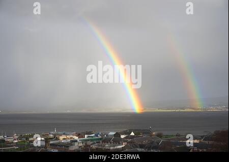 Arc-en-ciel lumineux au-dessus de la mer dans la nuit tempête Banque D'Images