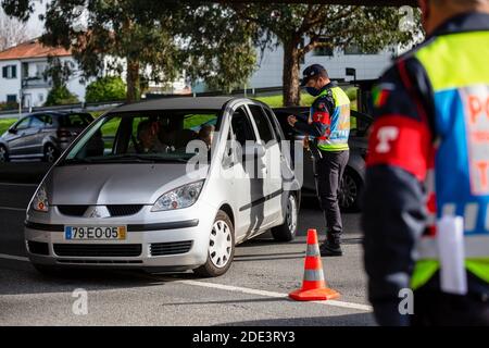 Porto, Portugal. 28 novembre 2020. Un agent de police interroge un conducteur sur sa destination et la raison de son départ à un point de contrôle de mobilité. Dans la ville de Porto, il y a déjà plusieurs agents de police qui suivent les nouvelles règles définies par le Gouvernement de Porto. Le Portugal compte 4,868 cas de plus et 87 décès. Crédit : SOPA Images Limited/Alamy Live News Banque D'Images