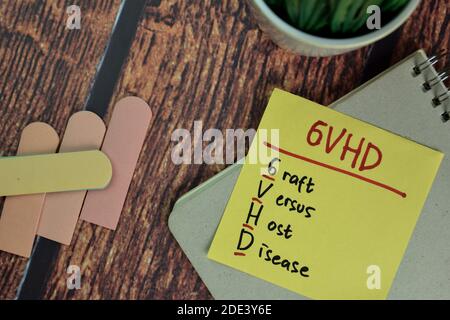 GVHD - maladie du greffon contre l'hôte écrire sur des notes adhésives isolées sur la table en bois. Banque D'Images