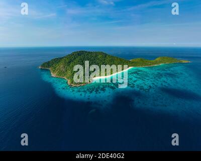 Vue aérienne d'une magnifique île tropicale pleine de jungle et de plage, entourée par un récif de corail. Banque D'Images