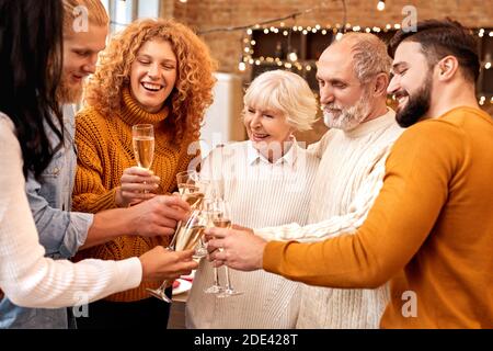Les gens tiennent un verre de champagne pour célébrer les vacances d'hiver Banque D'Images