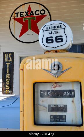 De vieux panneaux publicitaires et une pompe à gaz vintage sont exposés dans une entreprise du village de la route 66 de Williamsville, Illinois. Banque D'Images