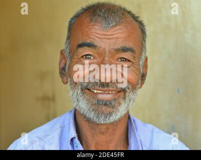 Heureux positif, homme indien Gujarati d'âge moyen avec de courts sourires de cheveux pour l'appareil photo. Banque D'Images