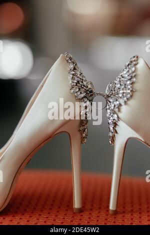 Anneau de mariage entre des talons de mariée blancs décorés de diamants Banque D'Images