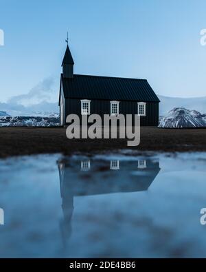 Petite église noire avec réflexion, Buakirkja, Arnarstapi, Islande Banque D'Images