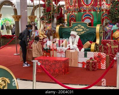 Philadelphie, Pennsylvanie, États-Unis. 28 novembre 2020. Une jeune fille maintient une distance sociale tout en visitant un Père Noël masqué au centre commercial King of Prussia Mall - visite avec le Père Noël pendant la COVID-19 - alors que le coronavirus se déforme aux États-Unis, les gens continuent à magasiner et à visiter le Père Noël dans un masque crédit: Don Mennig/Alay Live News Banque D'Images