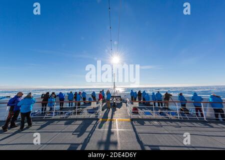 Passagers en bateau de croisière, sur pont, feu arrière, champ de glace, Atlantique Nord, côte est du Groenland, Danemark Banque D'Images