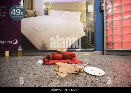 26 novembre 2020, Hessen, Francfort-sur-le-main : un homme sans domicile a installé son hébergement de nuit devant une publicité sur un panneau publicitaire dans le passage d'une gare. Le bus froid de la Frankfurt Verein für soziale Heimstätten (Frankfurt Association for social Homes) est en mouvement pour les sans-abri dans la ville pendant la saison froide entre 9:30 et 5:00 pm. Il offre le transport vers un abri de nuit, des couvertures, des sacs de couchage et du thé chaud. (À dpa 'avec thé et sacs de couchage - bus froid de Francfort en tournée') photo: Andreas Arnold/dpa Banque D'Images