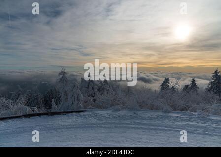 Magnifique paysage d'hiver avec route enneigée, arbres gelés, nuages d'invasion et ciel bleu au-dessus de Lysa hora colline à Moravskoslezske Beskydy mountai Banque D'Images