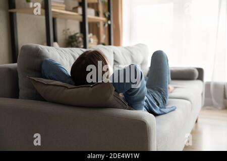Femme fatiguée se reposant sur un canapé dans un salon confortable Banque D'Images