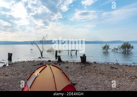 Vue sur la mer de Galilée sur le plateau du Golan en Israël. Camping sur les rives de la mer de Galilée. Tente rouge. Ciel bleu nuageux. Photo de haute qualité Banque D'Images