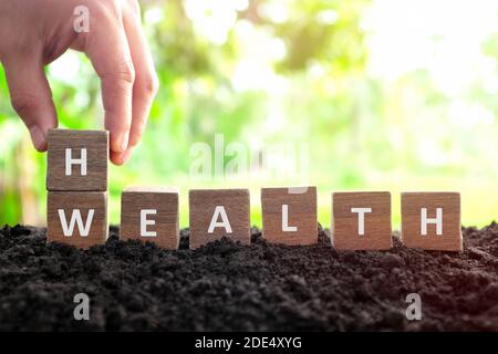 La santé est concept de richesse. Le changement de main ou le retournement de blocs de bois dés avec le mot richesse à la santé dans fond naturel. Banque D'Images