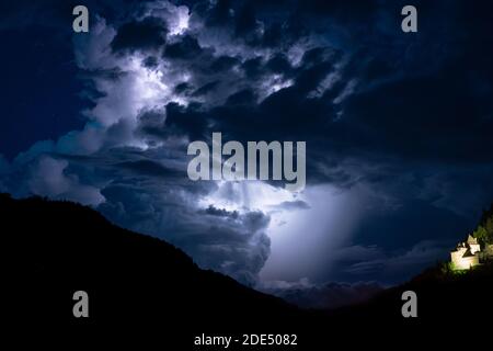 Image nocturne de la tour convective principale et à l'état de haut-plan d'un orage tournant sur la montagne, illuminé par la foudre Banque D'Images