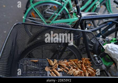 Panier métallique sur une bicyclette avec quelques feuilles sèches. Il se trouve parmi d'autres vélos garés sur le parking dans le centre-ville de Lucerne. Banque D'Images