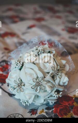 Un gros plan des beaux anneaux de mariage précieux sur un bouquet de fleurs Banque D'Images