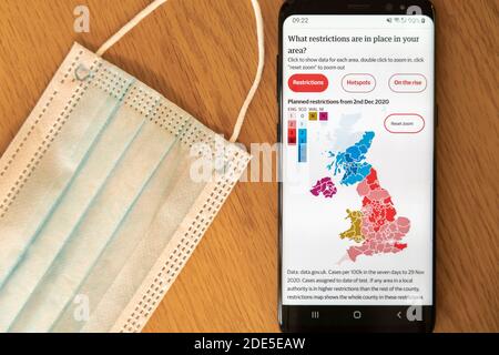 Restrictions locales prévues pour le coronavirus Covid-19 au Royaume-Uni 2 décembre 2020 sur un écran de téléphone mobile avec masque facial en arrière-plan Banque D'Images