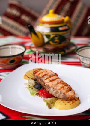 Steak de saumon sur un oreiller de légumes cuits. Style asiatique Banque D'Images