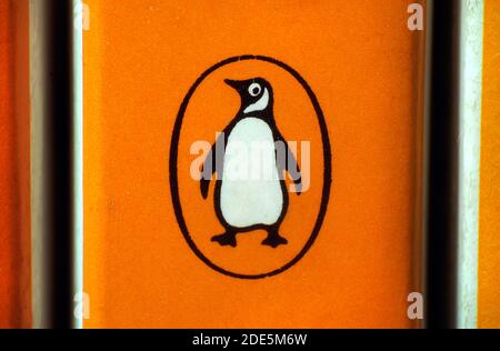 Gros plan du logo emblématique Penguin sur la colonne vertébrale du livre de poche orange Penguin 1970s. Penguin fait maintenant partie du conglomérat d'édition Penguin Random House. Banque D'Images