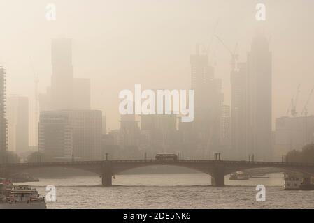 Ville pittoresque au coucher du soleil brumeux et orange, avec Central London City Skyline, célèbre bus rouge de Londres qui survole le pont de Lambeth, les gratte-ciels et les bureaux, tourné dans le cadre du confinement de Covid-19 en Angleterre, au Royaume-Uni Banque D'Images