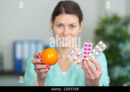 Female doctor holding apple et tas de comprimés Banque D'Images