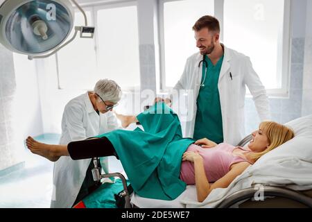 Équipe médicale, obstétricienne examinant la jeune femme enceinte à l'hôpital Banque D'Images