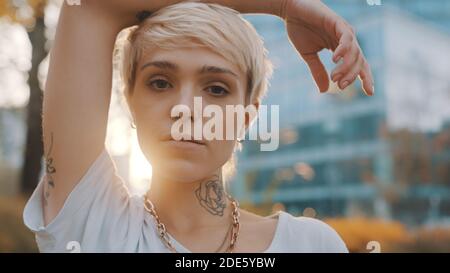 Portrait d'une belle jeune femme blonde aux cheveux courts dans le parc pendant le coucher du soleil. Photo de haute qualité Banque D'Images