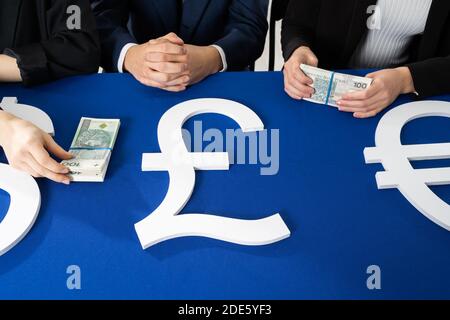 La commission à trois personnes divise l'argent destiné aux nécessiteux. Sur le tableau bleu se trouvent des liasses de billets de la valeur nominale de cent zlotys polonais. Banque D'Images