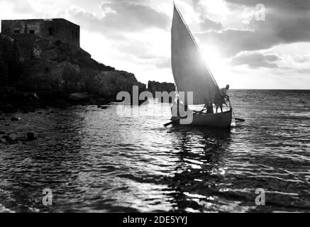 Légende originale : Césarée. (Kaisarieh). Scène de coucher de soleil avec bateau de pêche et pêcheur tirant son filet - emplacement: Israël--Caesarea ca. 1938 Banque D'Images