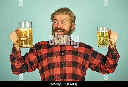 Hipster boit de la bière. Un gars mûr barbu tient du verre à bière. Toast santé. Sensation réelle. Fête des fêtes. Baccalauréat. Améliorer l'humeur. Ivre. Alcoolique. Un homme assoiffé boit de la bière au bar du pub. Banque D'Images