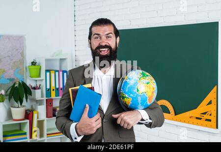 un géographe à barbe mature avec un costume de barbe et de moustache en classe scolaire, en classe. Banque D'Images