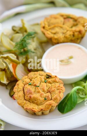 Muffins de légumes végétaliens avec sauce légère au piment-mayonnaise et salade de cornichons au concombre, gros plan sur un muffin Banque D'Images