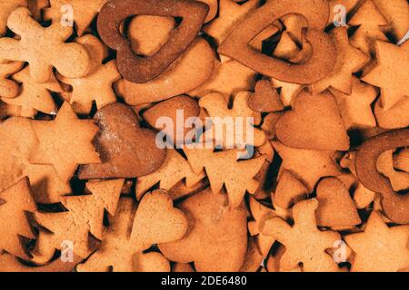 Juste cuit différentes formes pain d'épice biscuits tradition de Noël fond. Les cœurs, les étoiles, les arbres, les hommes de pain d'épice attendent un glaçage. Banque D'Images