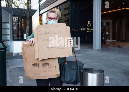 Philadelphie, Pennsylvanie, États-Unis. 29 novembre 2020. Une femme tient une affiche faite maison en attendant qu'un ami termine le Fraud Street Run. Crédit : Christopher Evens/ZUMA Wire/Alay Live News Banque D'Images