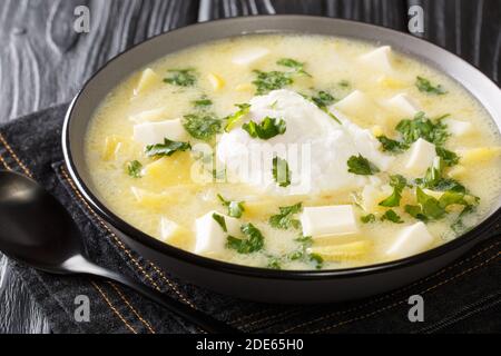 Délicieux bouillon de poulet américain latino avec pommes de terre, œufs, fromage blanc et coriandre dans un bol sur la table. Horizontal Banque D'Images