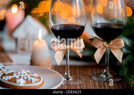 Ambiance de Noël festive avec deux verres de vin et une bougie sur la table de cuisine Banque D'Images