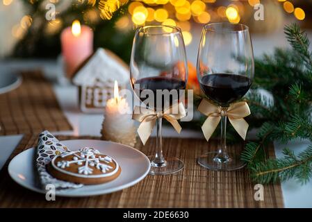 Ambiance de Noël festive avec deux verres de vin et une bougie sur la table de cuisine Banque D'Images