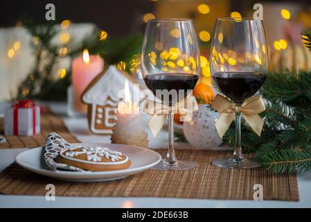 Ambiance festive de Noël avec deux verres de vin et une brûlure bougie sur la table de cuisine Banque D'Images