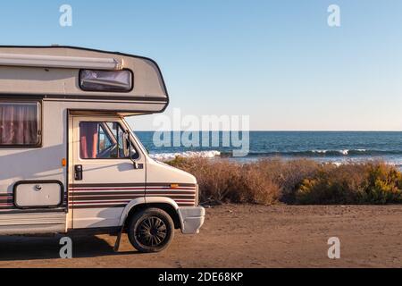 Espagne; novembre 2020: Caravane vintage garée en face de l'océan, vacances et sentiments de liberté. Un vieux campervan prêt à dormir. Côte d'Almería par Banque D'Images