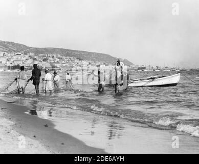 Légende originale: Carmel et Haifa. Pêche transportant dans un filet de traînée. Baie d'Haïfa et Carmel - lieu : Israël--Haïfa ca. 1920 Banque D'Images