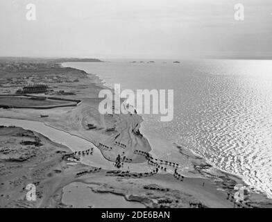 Histoire du Moyen-Orient - vues aériennes de la Palestine. Jaffa Auji River et Levant Fair. Embouchure de la rivière Auji. Effet de silhouette des chameaux fording. Promontoire de Jaffa à distance Banque D'Images