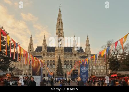 Les gens se socialisant dans les étals du marché de Noël devant le Rathaus avant les célébrations de la Saint-Sylvestre, Vienne, Autriche Banque D'Images