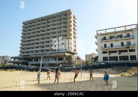 Varosha, Chypre. Les touristes jouent sur la plage devant les hôtels abandonnés de Varosha, Famagousta, qui fait maintenant partie de la partie turque occupée du nord de Chypre, (TRNC). Banque D'Images