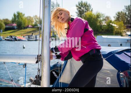 Jeune fille sportive en vêtements de sport sur un yacht à le quai est prêt pour une régate de voile Banque D'Images