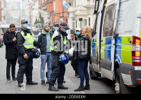 Londres, Royaume-Uni. - 28 novembre 2020 : une femme menottée, une des deux personnes détenues lors d'une manifestation anti-verrouillage dans la capitale. Banque D'Images