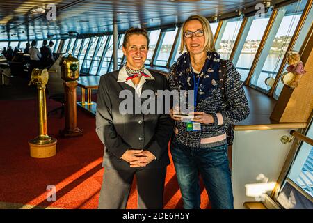 Sur le pont du pont Aven ferry à l'entrée du port de Cork en Irlande. Julie Moranges, responsable du divertissement, répond aux questions de la journaliste Angela Berg sur le pont Banque D'Images