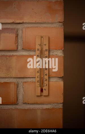 Thermomètre en bois sur un mur de briques Banque D'Images